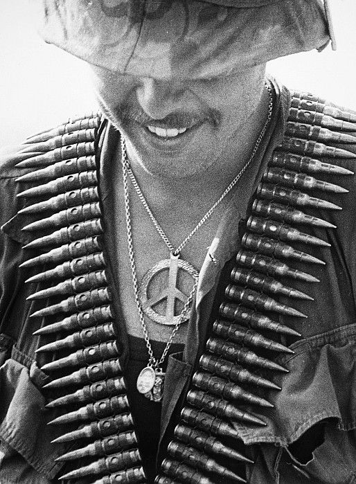 Vietnam GI with bandolier and peace sign. Photo: Tim Page.